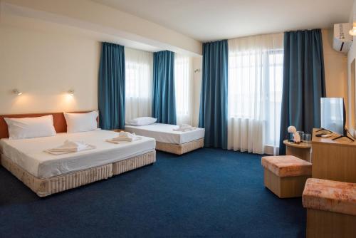 a hotel room with two beds and a television at Hotel Nadia in Primorsko