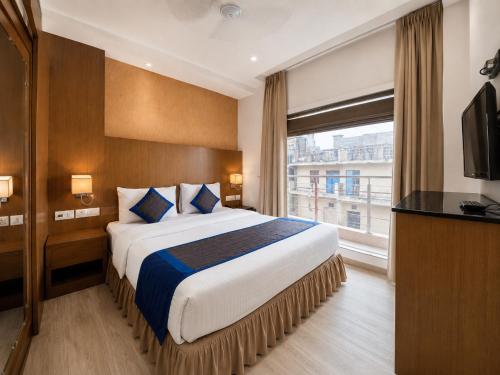 a hotel room with a large bed and a window at Hotel Hari Piorko - New Delhi Railway Station in New Delhi