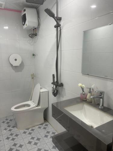 a bathroom with a toilet and a sink and a mirror at Bích Giản Tràng An in Nguyên Ngoại