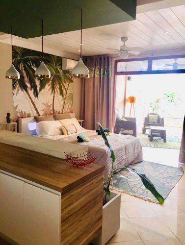 a bedroom with a large bed and a large window at Suite confortable avec vue imprenable in Punaauia
