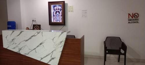 a marble counter in a room with a chair at Sri Krishna Residency in Tirupati