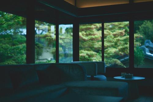 a room with two chairs and a table and windows at The Villa Higashiyama Roji Kazeno Heritage formaly HOTEL VMG VILLA KYOTO in Giommachi