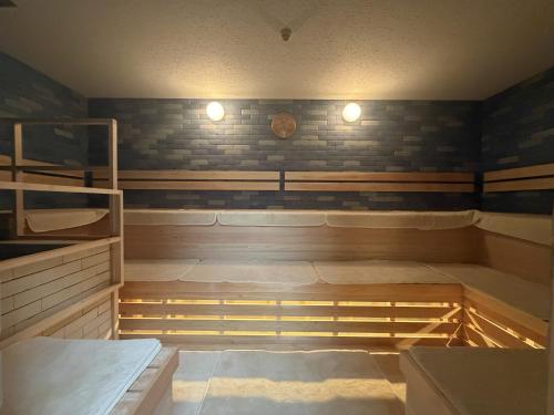 a room with two bunk beds and a clock on the wall at Capsule Inn Kinshicho in Tokyo