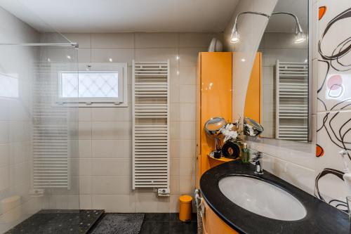 a bathroom with a sink and a mirror at Villa Micoco-Bassin d'Arcachon in Gujan-Mestras