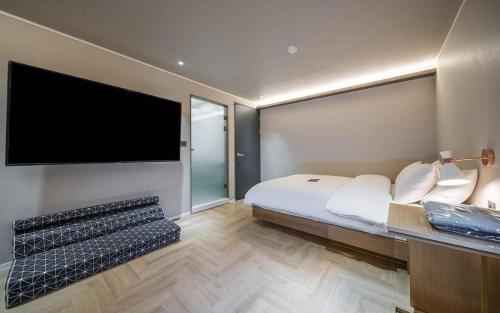 a bedroom with a bed and a flat screen tv at 넘버25 신촌점 in Seoul