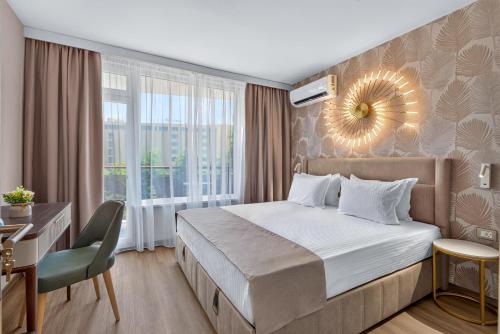 a bedroom with a bed and a desk and a mirror at Boutique Hotel Opal ULTRA ALL INCLUSIVE in Sunny Beach