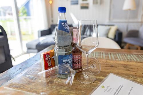 a bottle of alcohol and a wine glass on a table at Ferienhaus Hafenoase in Wandlitz