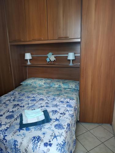 a bedroom with a bed with a blue and white blanket at Appartamento ITACA - CITRA 08065-LT-0722 in Ventimiglia