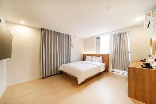 a hotel room with a bed and a window at From H Dongbaek Hotel by Kwon Gohyeon in Geoje