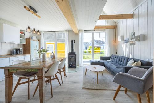 a kitchen and living room with a blue couch and a table at Ferienhaus Hafenoase in Wandlitz