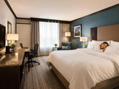 a woman laying on a bed in a hotel room at Wyndham Garden OKC Airport - Event Center, Indoor pool, Arcade Near Paycom, Fairgrounds in Oklahoma City
