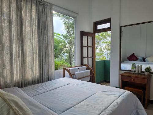 a bedroom with a bed and a large window at Polo Region Rest Inn in Haputale