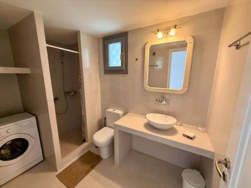 a bathroom with a sink and a washing machine at Rosalie Home - Aegean Poseidon in Tinos