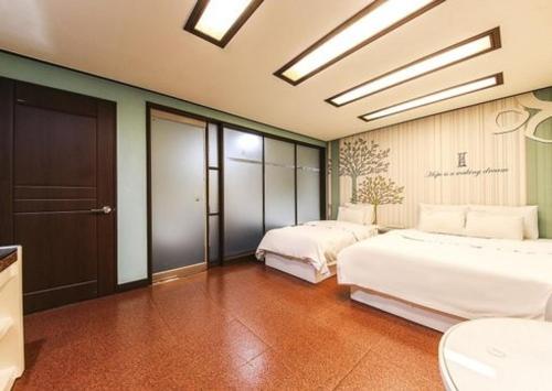 a bedroom with two beds and a bathroom at Hotel I Chuncheon Branch in Chuncheon