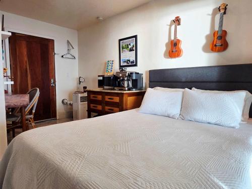 a bedroom with a bed with two guitars on the wall at Oceanfront studio see whales and dolphins in Pahoa
