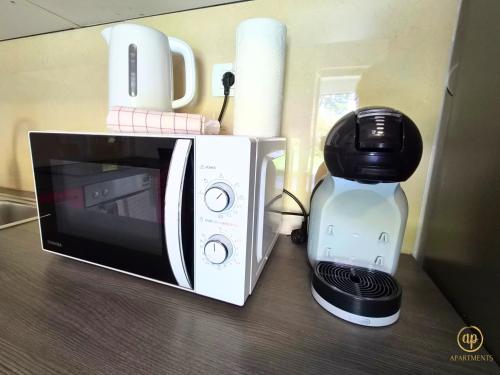 a microwave and a coffee maker on a table at Riverside Apartments - pet friendly in Sečovlje