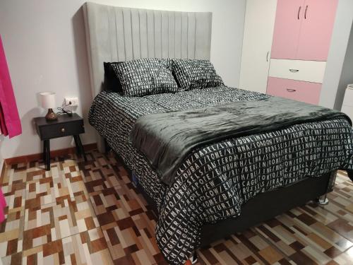 a bedroom with a bed and a table with a night stand at Alojamiento Wanka in Huancayo