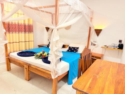 a bedroom with a canopy bed with a table at Arugam Bay Holiday in Arugam Bay