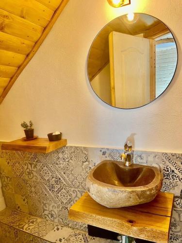 a bathroom with a stone sink and a mirror at Bat's Cave Hut Transylvania - Rustic Retreat in Sub Piatra