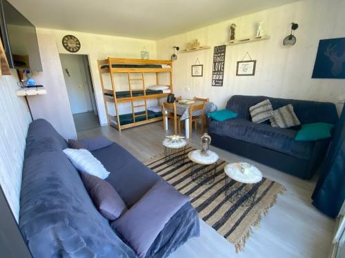 a living room with a blue couch and a bunk bed at Le Cocon d'Aurouze in Le Dévoluy