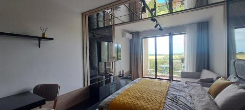 a bedroom with a bed and a large window at Infinity Studio, Shkorpilovtsi in Shkorpilovtsi