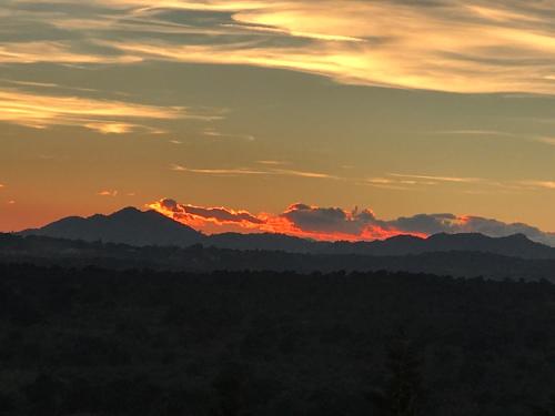 a sunset with mountains in the background at Finca el enebro in Valdemorillo