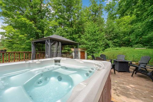a hot tub on a deck with a gazebo at Spa Game room Waterfront - Le Refuge Vert in Brébeuf