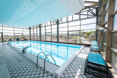 a swimming pool in a building with windows at Wyndham Cluj in Cluj-Napoca