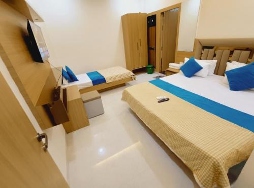 a hotel room with two beds and a television at Hotel Shree krishna in Ujjain