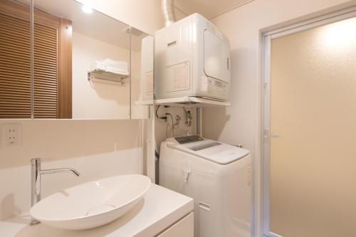 a bathroom with a sink and a washing machine at Hillside Sea View Resort Villa Gushikumui in Motobu
