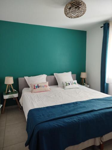 a bedroom with a large bed with a blue wall at Lénola en Ardèche in Labeaume