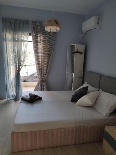 a bedroom with a large white bed with curtains at Dream house steps from sea in Pídima Kyrás