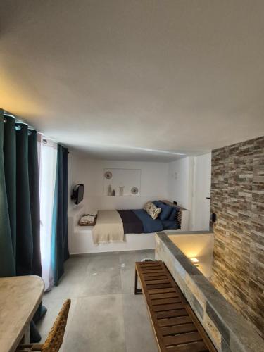 a bedroom with a bed and a brick wall at Apomero Apartment in Rochari Panormos in Panormos
