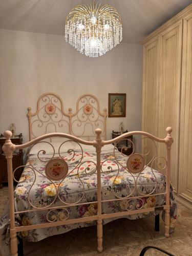 a bed in a bedroom with a chandelier at Le Coccole Del Trasimeno in Tuoro sul Trasimeno