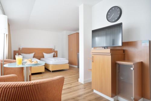 a living room with a couch and a table with a tv at Schöne Apartments I Kostenloses Parken I home2share in Münster