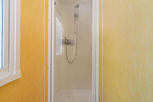 a shower stall in a bathroom next to a window at 23.Mobil-home option clim-5pers in Calviac