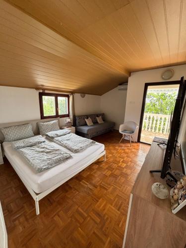 a bedroom with a bed and a couch in a room at Villa Alexa Cesarica in Cesarica