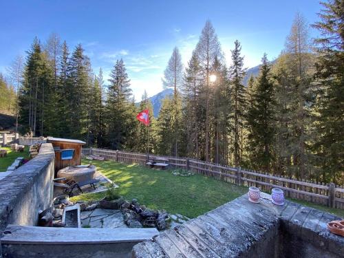 a view of a backyard with a fence and a field at Carolina Gatekeeper's House in Zernez