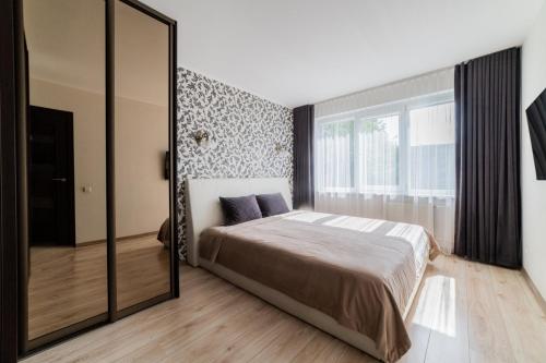 a bedroom with a bed and a large mirror at VakarDi Apartments in Šiauliai