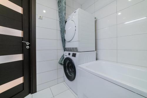 a washing machine in a bathroom next to a door at VakarDi Apartments in Šiauliai
