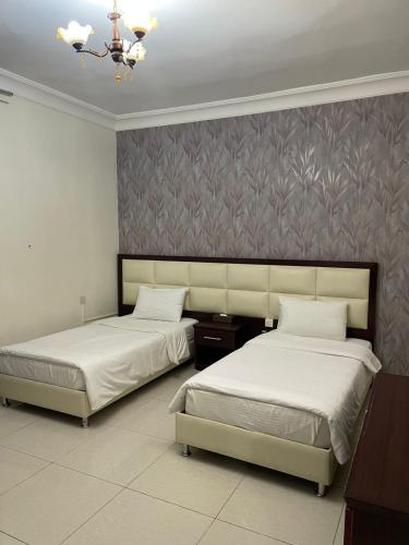 two beds in a room with two beds sidx sidx sidx sidx at فندق قمة البستان الرفاع in Arar