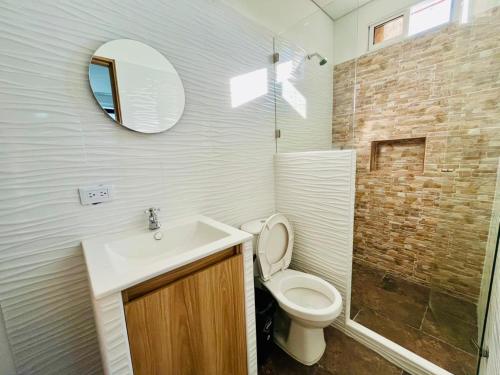 a bathroom with a toilet and a sink and a mirror at Angel Mari a Doradal in Doradal