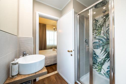 a bathroom with a white sink and a shower at Hotel Serenella in Sirmione