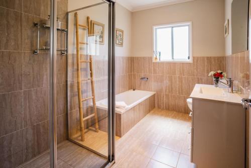 a bathroom with a shower and a tub and a sink at Hunter Moon in Broke