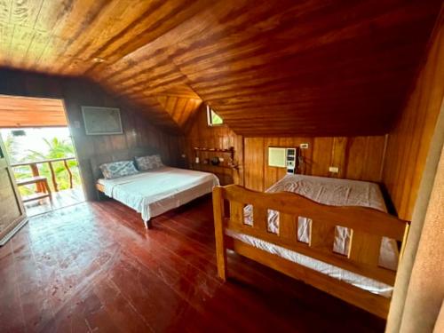 a bedroom with two beds and a wooden ceiling at Sunset Haven in Siquijor