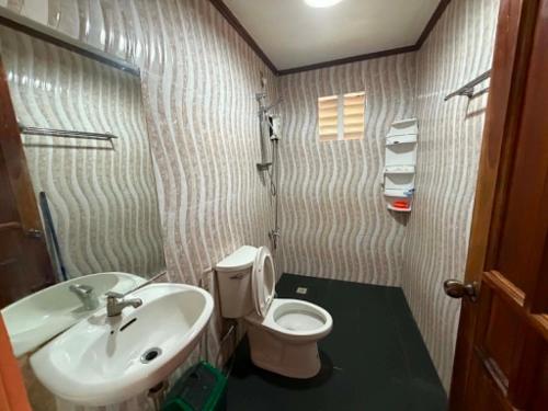 a small bathroom with a toilet and a sink at Sunset Haven in Siquijor