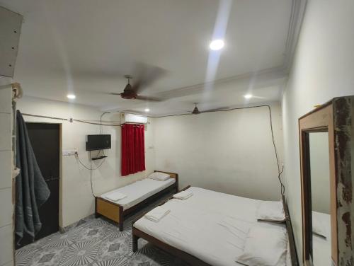 a small room with two beds and a mirror at Hotel Geetanjali in Lucknow