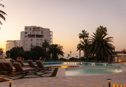 a swimming pool with lounge chairs and a building at President Hotel in Cape Town