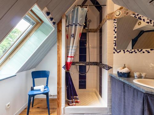 a bathroom with a shower and a blue chair at Escapade Bretonne in Lannion
