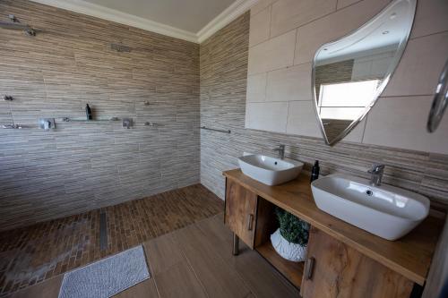 a bathroom with two sinks and a mirror at Colchester Suites - Travel Addo Group in Cannonvale